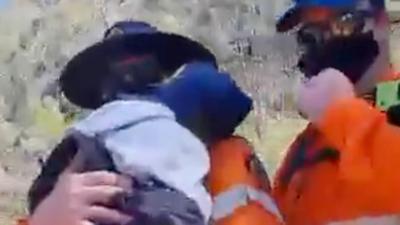 Rescuers holding boy