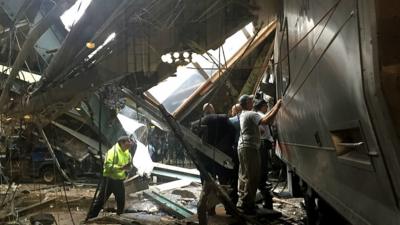 Staff assess the damage of the train crash