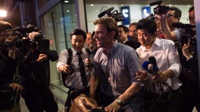 Rupert Wingfield-Hayes surrounded by media at Beijing airport