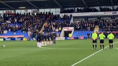 Players on the pitch during applause at Croud Meadow