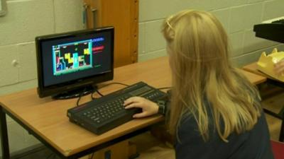 A girl using an old computer