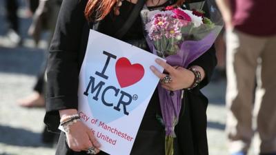 A woman holds an "I heart MCR" sign.