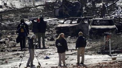 Investigators work near the site of an explosion on 2nd Avenue