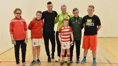 Nick Bright receives a handball lesson from world champion Aisling Reilly