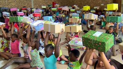 Children holding up presents in boxes