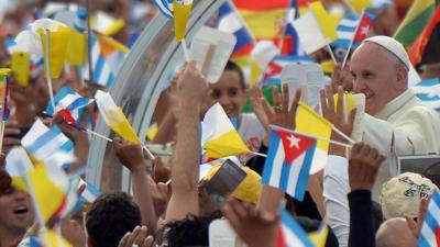 Pope almost obscured by a mass of flags and waving hands as he greeted by crowds in Havana