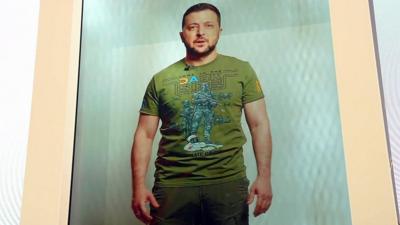 A 3D projection of Ukrainian President Volodymyr Zelensk. He is wearing a green Star Wars T-shirt and green trousers