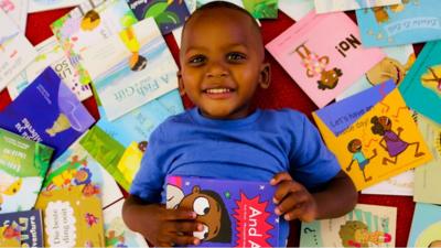 A child surrounded by books