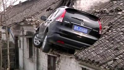 Car stuck in roof of house in China