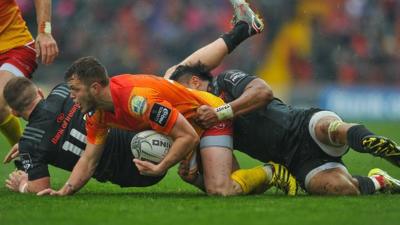 Steff Hughes of Scarlets is tackled by Francis Saili and Andrew Conway of Munster
