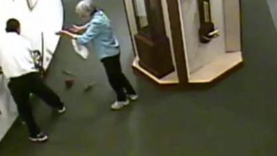 A man knocking at clock off the wall at the National Watch and Clock Museum in Columbia, Pennsylvania.