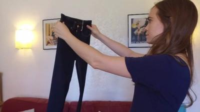 Woman holding up a pair of jeans