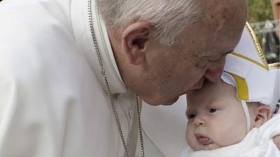 Pope Francis kisses a baby dressed as the Pope in Philadelphia
