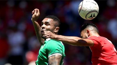 Northern Ireland Josh Magennis goes up for an aerial challenge in San Jose