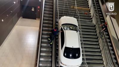 Firefighters pull a car up a Madrid staircase