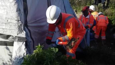 Crew member uses sledgehammer