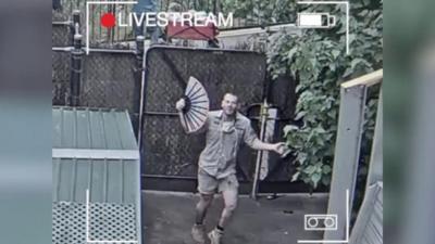 zookeeper mid dance with fan in his hand