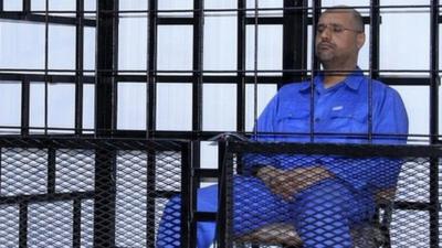 File image from 2014 - Saif al-Islam Gaddafi, son of late Libyan leader Muammar Gaddafi, attends a hearing behind bars in a courtroom in Zintan