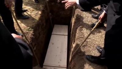 Coffin lowered into the ground