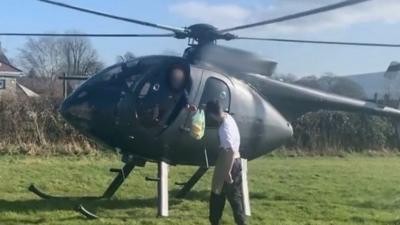 Pilot takes sandwich from shop worker