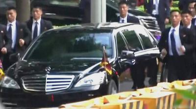 Bodyguards run alongside the car of North Korea leader Kim Jong-un