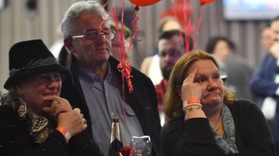 Voters look on as they follow results of the national election