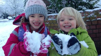 Two children playing in snow in Manchester