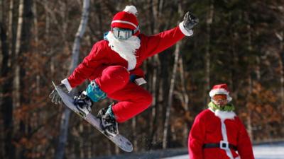 A snowboarder dressed as Santa