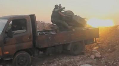 Man firing gun from back of truck