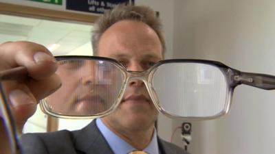 The BBC's Matthew Hill holding a pair of adjusted glasses