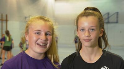 Two girls in a sports hall.