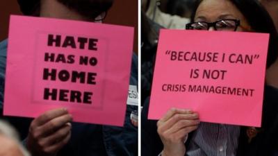 People holding up signs