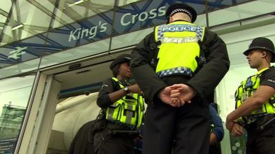 Three British Transport Police officers outside King's Cross station in London