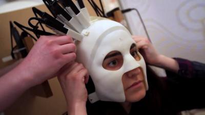 A woman has a brain scanner mask fitted