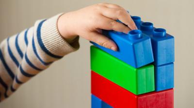 A child with with plastic building blocks