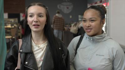 Two young women, one with long dark hair and one with her hair in a bun