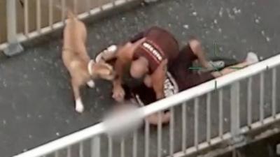 A man restrains another man on the ground