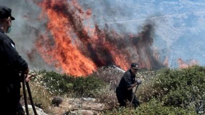 Firefighters battle a fire in Athens on 17 July 2015