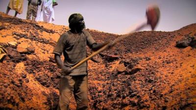 A man digging for gold in the Sahara desert in Mauritania