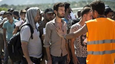 Migrants wait to complete registration in Lesbos