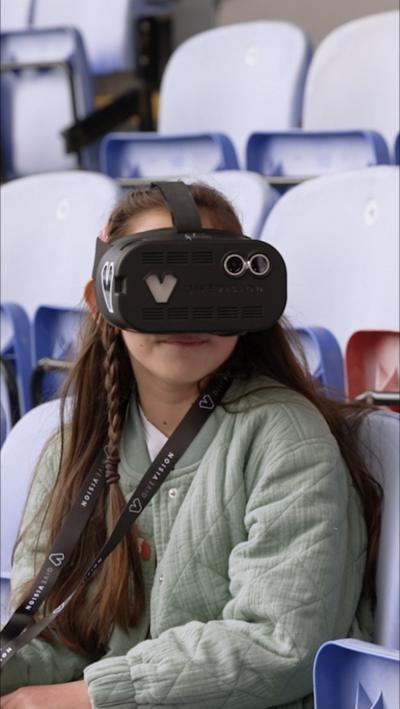Young football fan Sophia wearing a black headset with a camera