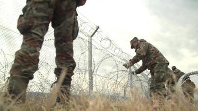 Macedonian troops build a wire fence on Macedonia's border with Greece