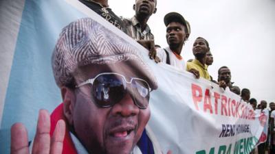 Papa Wemba fans hold sign of the late singer