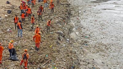 Workers on a beach in the Dominican Republic clearing up the rubbish that has been left from a recent storm