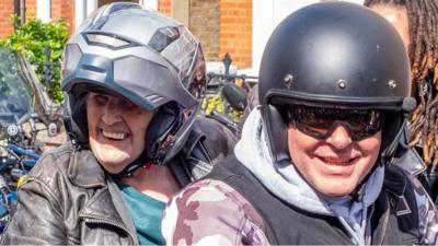 Anne Turner on the back of a Harley-Davidson