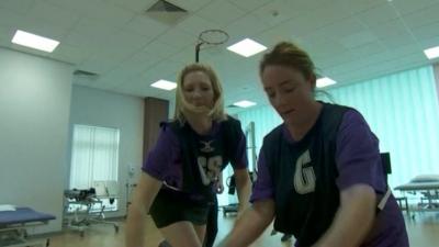 Two women playing netball