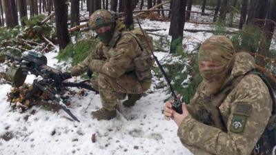 Two soldiers crouching in the snow