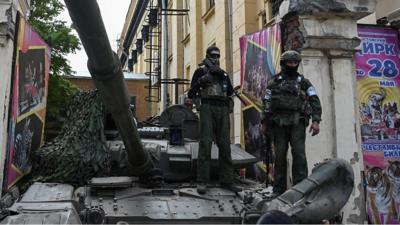 Two masked soldiers standing on a tank