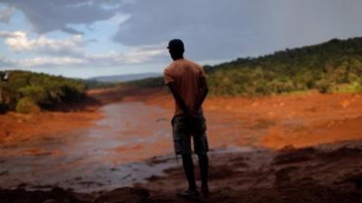 Volunteer looks at toxic sludge, Brumadinho