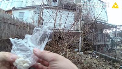 An officer holding a bag of pills